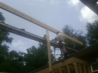Carpenter setting a ridge beam over a new addition frame — Ice Dam Removal by Roofing Brothers in Somers Point