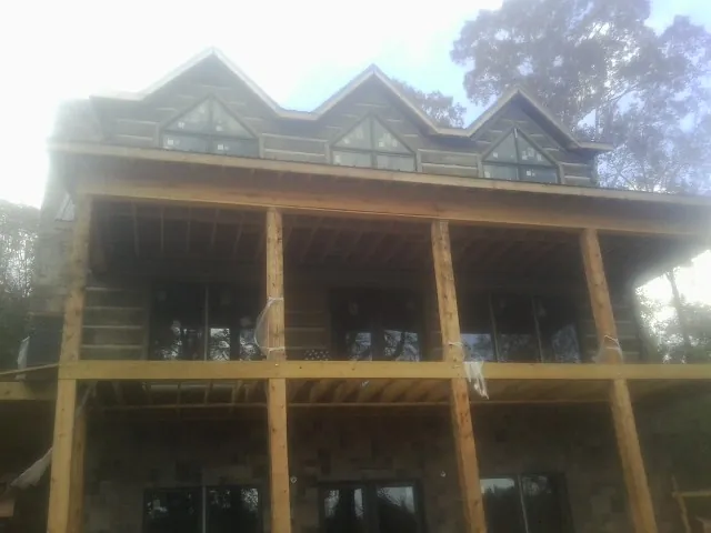 Dormers and porch framing on a large log home under construction — Roof Coating work by our crew in Somers Point